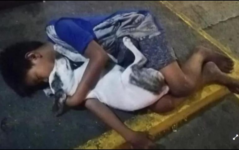 El menor, el cual no ha sido identificado, vive en las calles de Manilla, Filipinas, y duerme abrazado a su perro para soportar el frío. FACEBOOK/ Jem Villomo