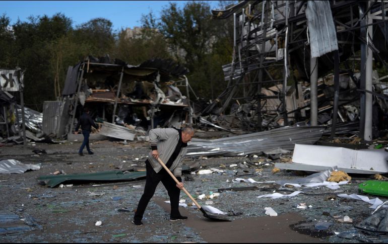 Un hombre limpia los escombros de una tienda de autopartes luego del ataque ruso en Ucrania. AP / L. Correa