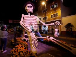 Visitantes observan una figura de calavera gigante en las calles del municipio de Atlixco, Puebla. EFE / H. Ríos
