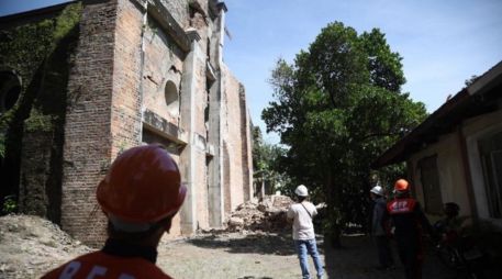 Bomberos inspeccionan los daños en una iglesia en el pueblo de Dingras. EFE/B. Sipin
