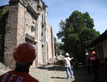 Bomberos inspeccionan los daños en una iglesia en el pueblo de Dingras. EFE/B. Sipin
