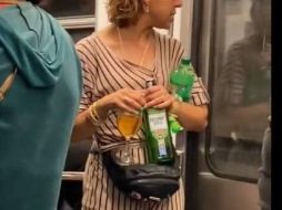 En el video se ve que la mujer sostiene una copa, una botella de whisky y un refresco. ESPECIAL