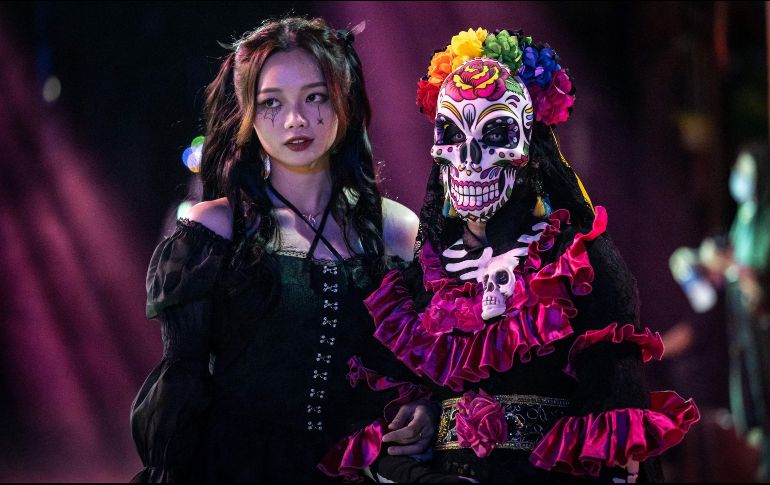 Personas disfrazadas caminan por las calle durante una celebración antes en Guangzhou, China. AFP