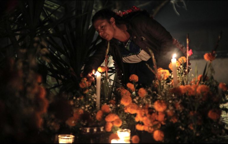 Una mujer asiste hoy al panteón de Pátzcuaro en el estado de Michoacán. Familias mexicanas volvieron a llenar de vida los cementerios, después de dos años de restricciones debido a la pandemia. EFE / I. Villanueva