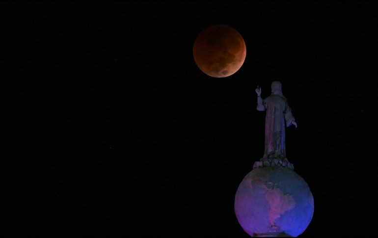 La Luna de sangre se vio durante un eclipse lunar total sobre el monumento al Salvador del Mundo en la Plaza Salvador del Mundo, en San Salvador. AFP / M. Recinos