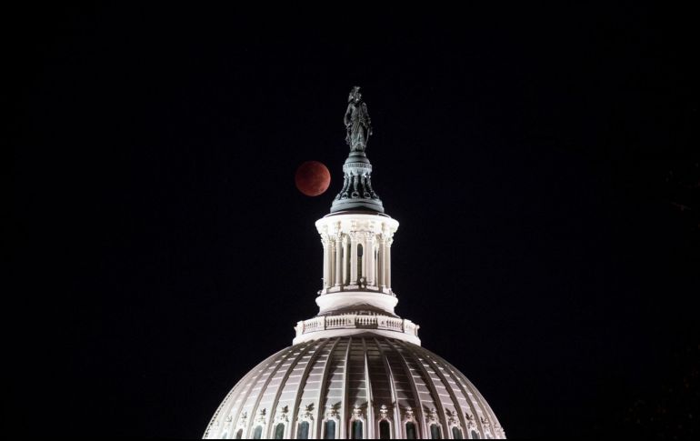 El eclipse visto detrás de la Estatua de la Libertad, en la parte superior de la cúpula del Capitolio de EU, en la mañana de las elecciones intermedias en Washington, Estados Unidos. AFP / S. Reynolds