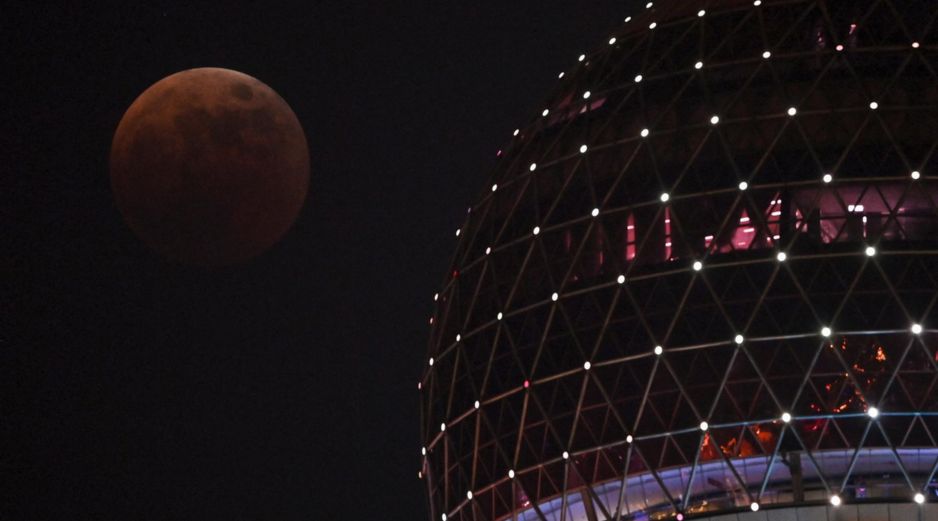 La Luna de sangre se ve desde el paseo del Bund durante un eclipse total en Shanghái, China, este 8 de noviembre de 2022. AFP / H. Retamal