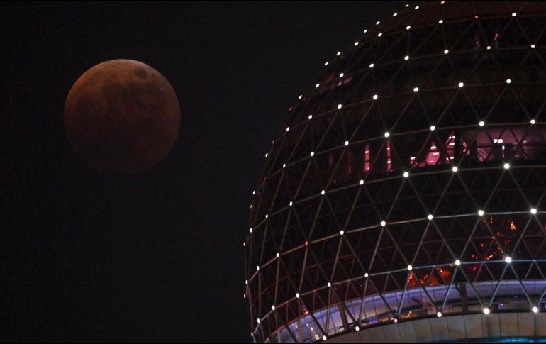 La Luna de sangre se ve desde el paseo del Bund durante un eclipse total en Shanghái, China, este 8 de noviembre de 2022. AFP / H. Retamal