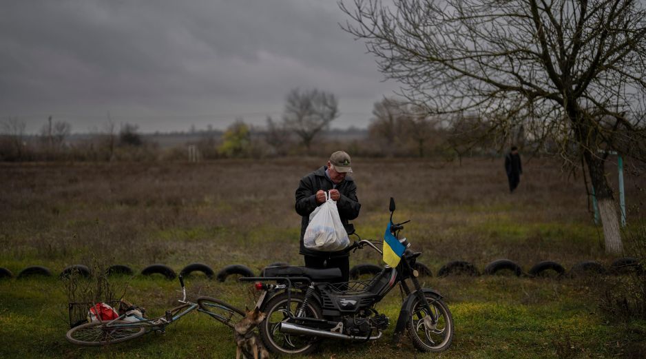 Un hombre lleva comida donada a su hogar a bordo de una bicicleta. AP/A. Armangue