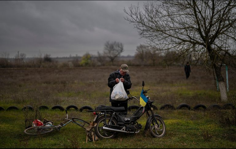 Un hombre lleva comida donada a su hogar a bordo de una bicicleta. AP/A. Armangue