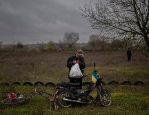 Un hombre lleva comida donada a su hogar a bordo de una bicicleta. AP/A. Armangue