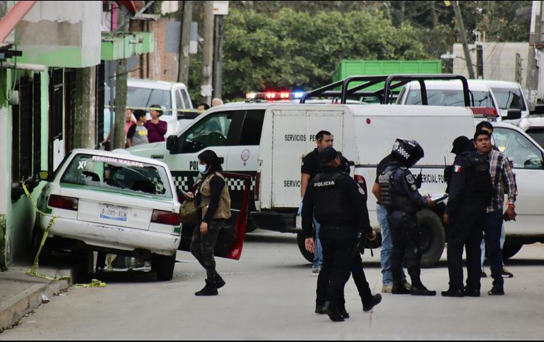 Miembros de la policía municipal y agentes periciales inspeccionan una escena del crimen donde fue asesinado el periodista Pedro Pablo Kumul, hoy en Xalapa. EFE