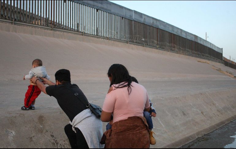 Una pareja con sus hijos corre sobre el Río Bravo, en el punto fronterizo del Paso del Norte, en Ciudad Juárez, con el fin de ingresar a territorio estadounidense. EFE/ARCHIVO