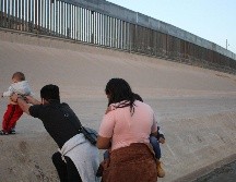 Una pareja con sus hijos corre sobre el Río Bravo, en el punto fronterizo del Paso del Norte, en Ciudad Juárez, con el fin de ingresar a territorio estadounidense. EFE/ARCHIVO