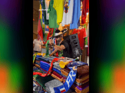 Con la ayuda de un audio de la característica arenga propagandística de cobijas, el hombre entretiene a varios transeúntes. TWITTER / @Ramonen10