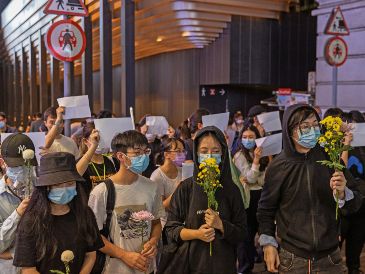 Manifestantes chinos marcharon con flores en Hong Kong, también llevaron páginas blancas, que simbolizan la “censura” que enfrentan en redes sociales y otros medios. EFE
