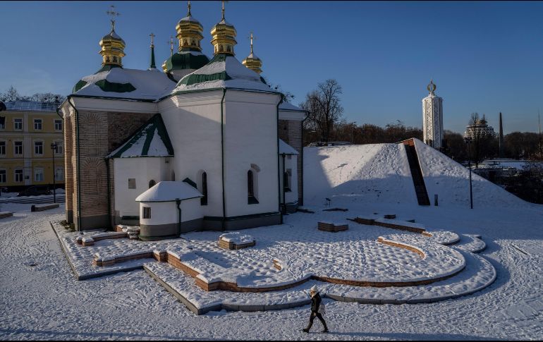 Una mujer pasa frente al patio de una iglesia cubierto de nieve en Kiev, Ucrania. AP/B. Armangue