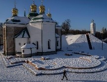 Una mujer pasa frente al patio de una iglesia cubierto de nieve en Kiev, Ucrania. AP/B. Armangue