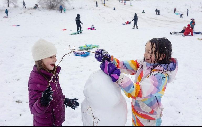 Doas niñas construyen un muñero de nieve en medio de una fuerte nevada en Idaho. AP/S. Miller
