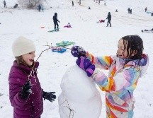 Doas niñas construyen un muñero de nieve en medio de una fuerte nevada en Idaho. AP/S. Miller