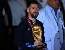 Lionel Messi fue el primero en bajar del avión para mostrar la copa mundial a los aficionados que aguardaban en el aeropuerto. AFP/L. Robayo