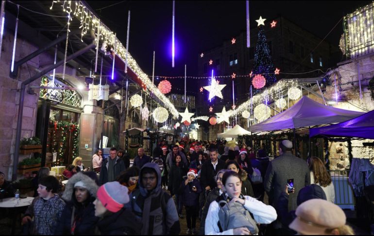 La gente visita un mercado navideño que tiene lugar en la Puerta Nueva en el Barrio Cristiano en la Ciudad Vieja de Jerusalén, en Nochebuena. EFE/A. Sultán