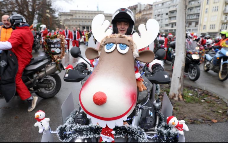 Un motociclista vestido con traje de Papá Noel posa para una foto en Belgrado, Serbia. Un grupo de estos se reunió en la capital para un viaje conjunto para llevar regalos de Navidad para niños de escasos recursos. EFE / A. Cukic
