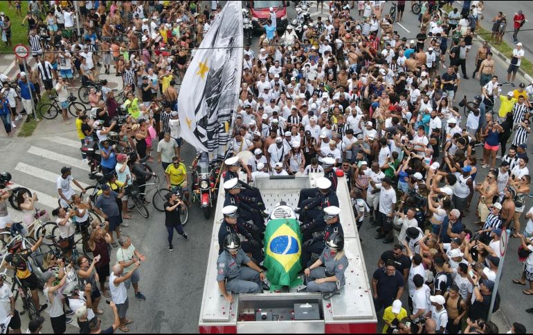 Centenares de aficionados del Santos siguen ruidosamente el cortejo fúnebre de Pelé, que partió este martes del estadio Vila Belmiro y recorre a paso lento las calles de la ciudad brasileña de Santos. EFE / A. Lacerda