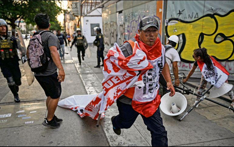 Manifestantes huyen de la policía, durante la jornada de protestas que ayer inundaron la capital peruana. AFP