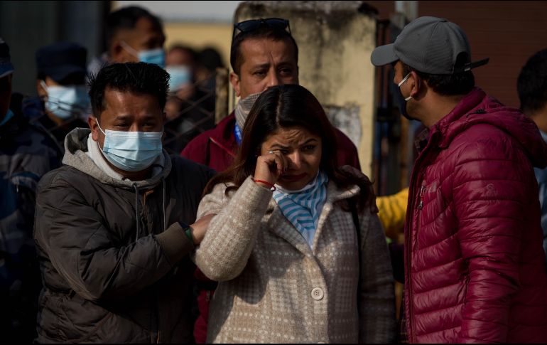 Familiares de las víctimas de un accidente aéreo de Yeti Airlines esperan a que los restos de sus seres queridos sean cargados en camiones. XINHUA/S. Shrestha