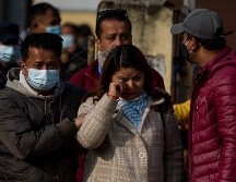 Familiares de las víctimas de un accidente aéreo de Yeti Airlines esperan a que los restos de sus seres queridos sean cargados en camiones. XINHUA/S. Shrestha