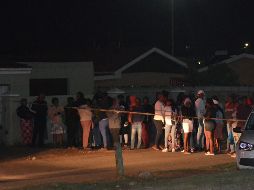 Una multitud de curiosos se congregó el lunes fuera de la casa donde se produjo el tiroteo. AFP/L. Mehlwana