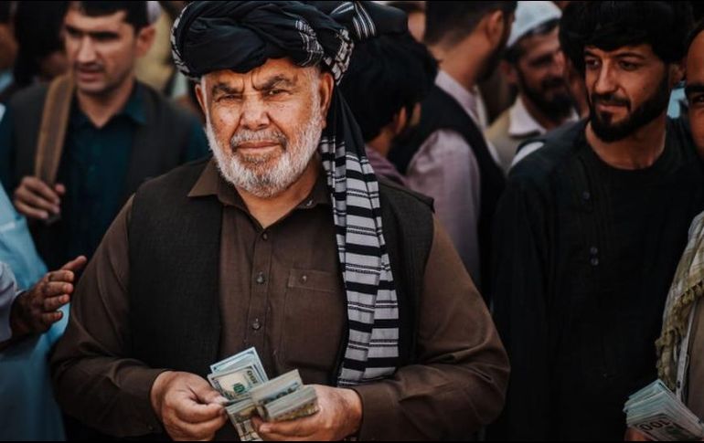 Un cambista ofrece dólares en un mercado de Kabul. GETTY IMAGES