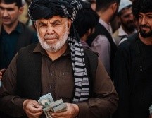 Un cambista ofrece dólares en un mercado de Kabul. GETTY IMAGES