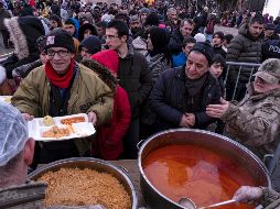Damnificados de Diyarbakir, en Turquía, reciben alimentos calientes tras el potente sismo que arrasó con sus viviendas. EFE/R. Tekin