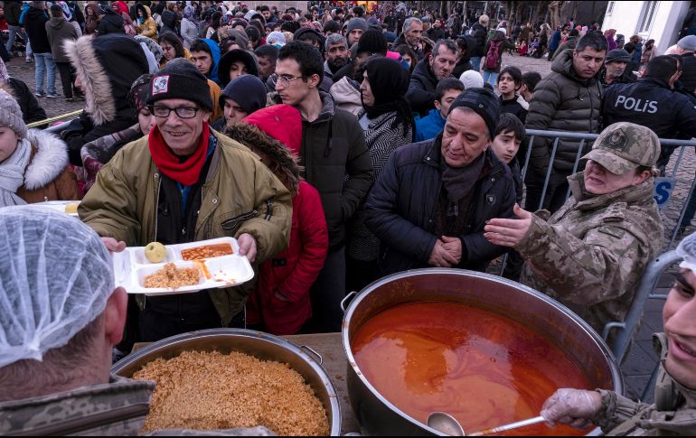Damnificados de Diyarbakir, en Turquía, reciben alimentos calientes tras el potente sismo que arrasó con sus viviendas. EFE/R. Tekin