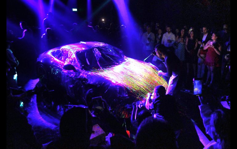 El artista intervino un automóvil de lujo enmarcada la actividad por una atmósfera en destellos neón que provenían de la obra expuesta y además con música de DJ de fondo. EL INFORMADOR / A. Camacho