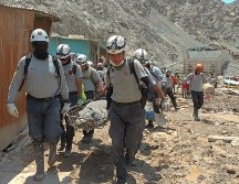 Rescatistas recuperan cuerpos de las montañas de lodo. AFP