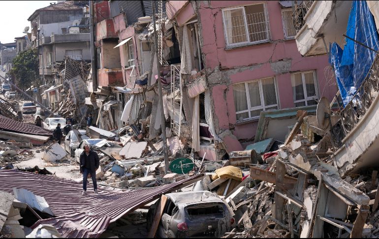 Una persona camina entre edificios colapsados en medio de un panorama desolador en Hatay, Turquía. AP/H. Malla