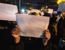 Varios de los que hicieron parte de las protesas de noviembre sostuvieron hojas blancas de papel como símbolo de su frustración. GETTY IMAGES