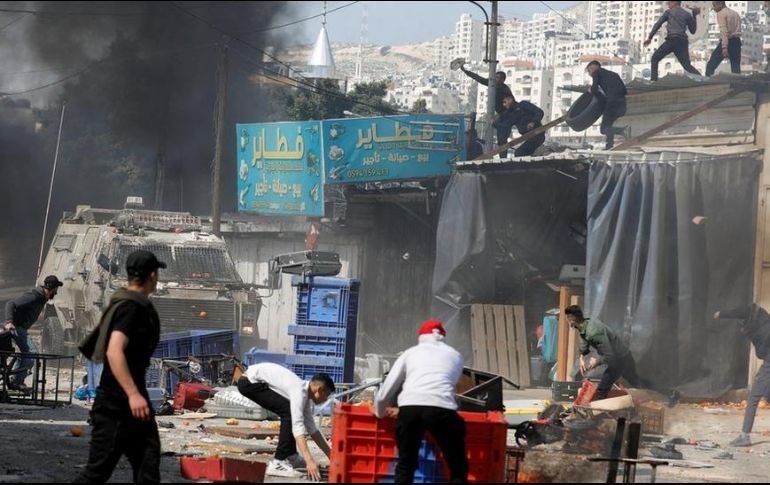 Jóvenes palestinos lanzaban piedras y otros objetos contra los vehículos blindados israelíes que ingresaron a Nablus el miércoles. REUTERS