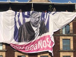 Ante las protestas de asistentes a la manifestación, jóvenes subieron al edificio y desde las ventanas cortaron la manta. TWITTER/@wadelacruz