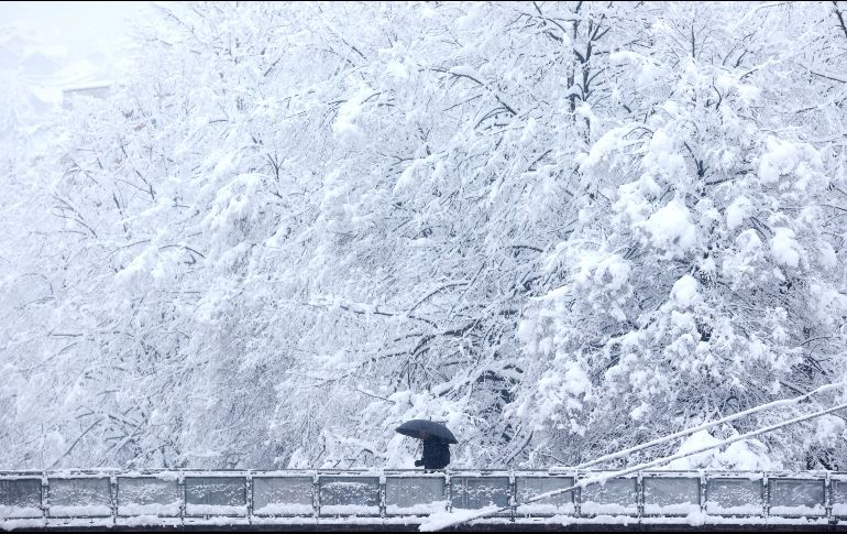 Un hombre que se protege con una sombrilla cruza un puente en medio de un nevado pasaje en Sarajevo, Bosnia. AP/A. Durgut