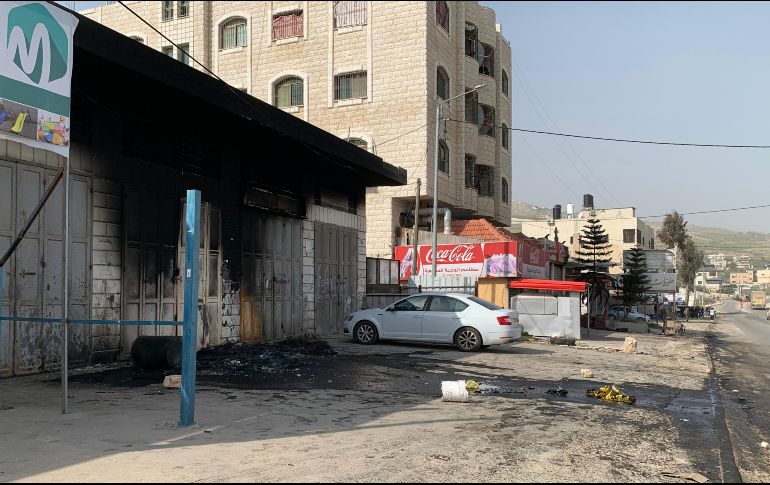 Vista de edificios, coches y negocios palestinos calcinados en el pueblo palestino de Huwara este lunes tras el asalto anoche de unos 400 colonos. EFE/P. Duer