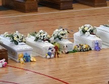 Sobre cada ataúd había un ramo de flores. Algunas personas colocaron juguetes sobre los ataúdes de los niños. EFE/C. Imbesi