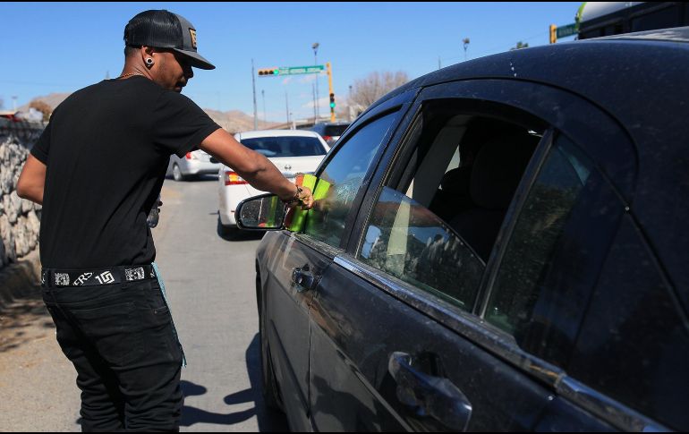 Al no contar con documentación que acredite su identidad, los extranjeros trabajan limpiando vidrios en los cruceros en Ciudad Juárez. EFE/L. Torres