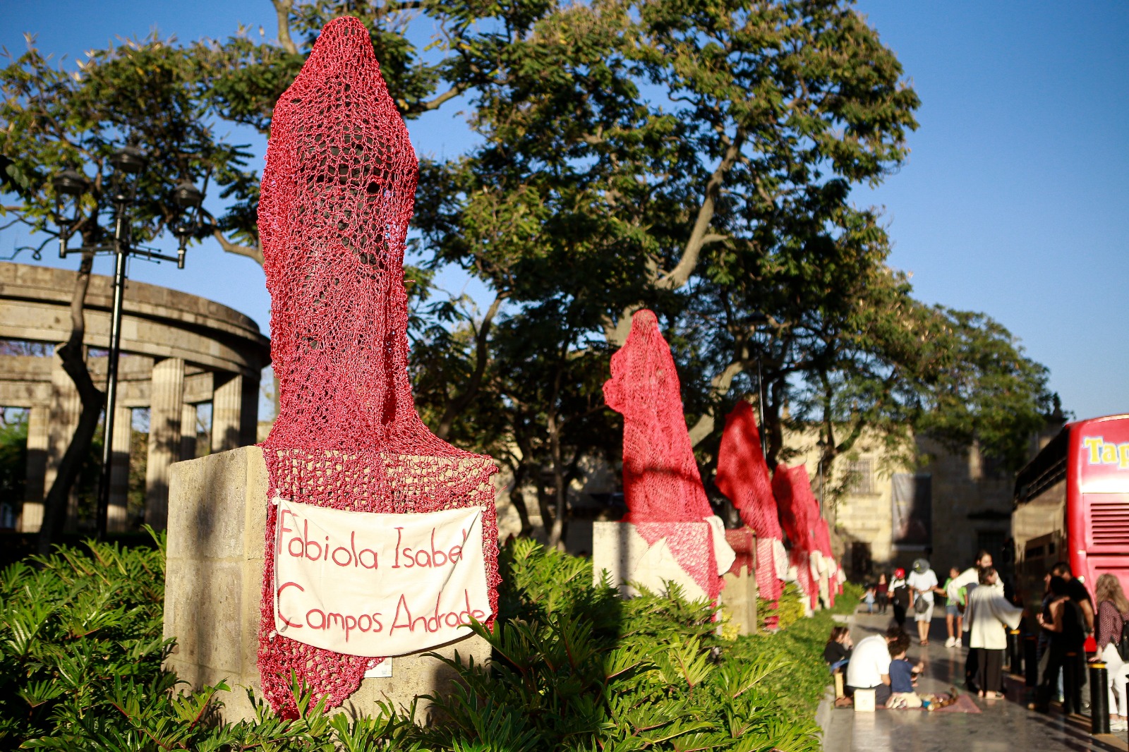 Mujeres de Colectiva Hilos cubrieron las estatuas de la rotonda de los hijos ilustres con redes de hilo rojo para reemplazar sus nombres por los de mujeres. EL INFORMADOR/ CARLOS ZEPEDA