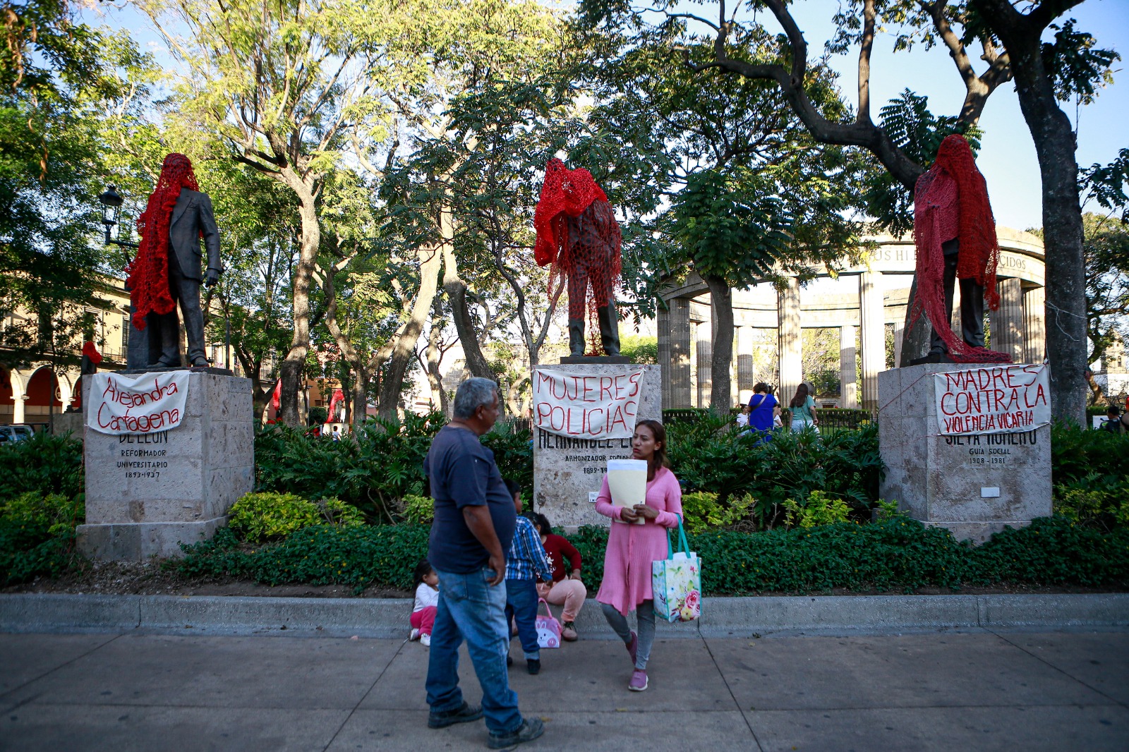 Mujeres de Colectiva Hilos cubrieron las estatuas de la rotonda de los hijos ilustres con redes de hilo rojo para reemplazar sus nombres por los de mujeres. EL INFORMADOR/ CARLOS ZEPEDA