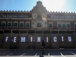Una mujer camina afuera del Palacio Nacional, cercado por vallas, ante las marchas del 8 de marzo, Día Internacional de la Mujer. EFE / I. Esquivel