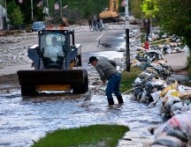 Eesidentes de Red Lodge, Montana, limpian lodo, agua y escombros tras una de las multiples inundaciones causadas por 